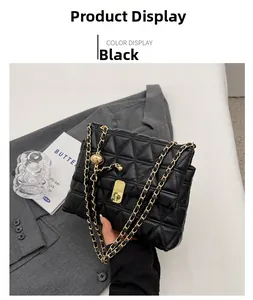 Close-up of black quilted leather chain bag with golden decorative ball and turn-lock
