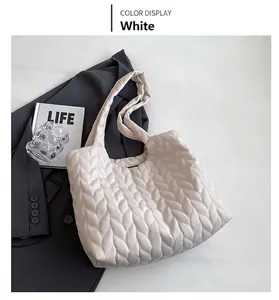 Detail of white quilted tote bag featuring unique leaf-pattern geometry and soft texture
