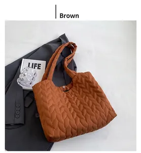 Detailed macro view of brown quilted tote bag texture with button on grey suit