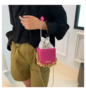 Detail of rose pink woven bucket bag with white drawstring liner and gold chain strap
