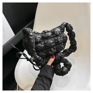 Detail of black quilted cloud bag with textured fabric and leather bow drawstring