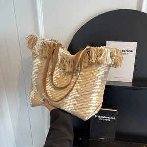 Bohemian woven tote bag with fringe detail and brown leather straps for daily commute