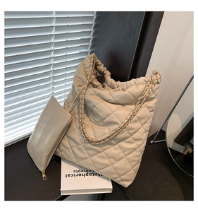 Detail of beige quilted tote bag with golden chain strap and matching small pouch