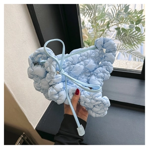 Detail of light blue cloud bag with pleated texture and stylish moon shape structure