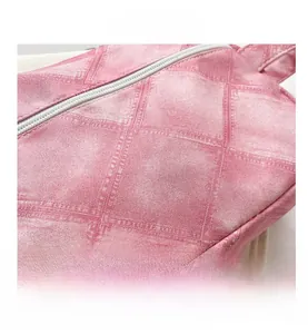 Gros plan sur la texture du tissu matelassé rose et le zip de la trousse cosmétique