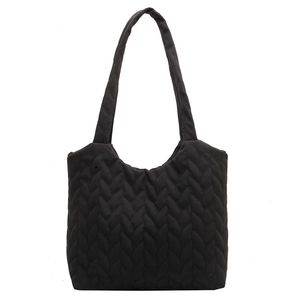 Black quilted tote bag with woven texture and long strap for stylish commuting