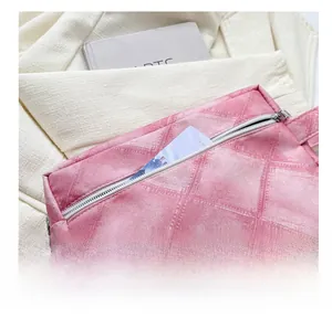 Détail de la trousse de toilette rose à carreaux avec poche zippée et texture du tissu