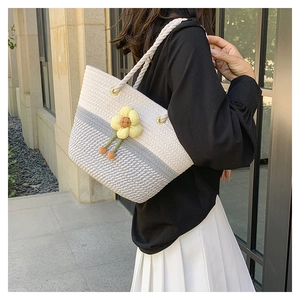 Détail du sac cabas tissé main avec fleur jaune 3D et poignées en corde épaisse