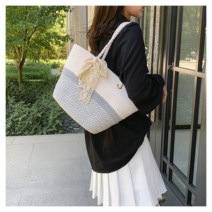 Detailed texture of white and grey woven cotton tote bag with soft lace bow detail