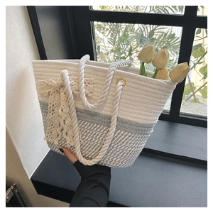 Detail of woven tote bag featuring soft cotton rope texture and large lace bow accent