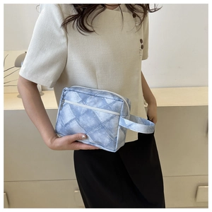 Détail de la trousse de toilette imprimé denim bleu avec fermeture éclair blanche