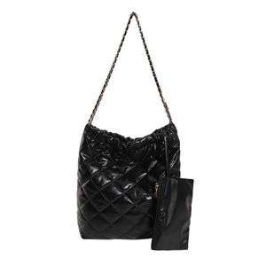 Black quilted tote bag with chain strap and matching coin pouch on white background