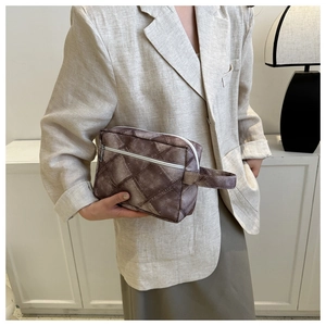 Détail de la trousse de toilette marron foncé avec fermetures éclair blanches
