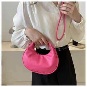 Détail du sac demi-lune rose affichant la texture en cuir PU et le zip doré brillant