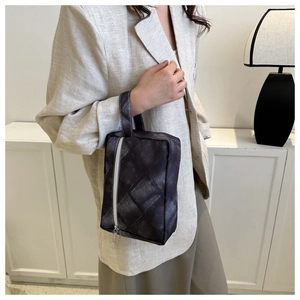 Détail du sac à main matelassé gris avec fermeture éclair blanche en décor intérieur