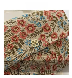 Macro shot of colorful floral woven fabric texture and gold clover metal buckle detail