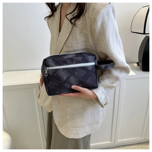 Détail de la trousse de maquillage matelassée noire avec fermeture éclair et poignée