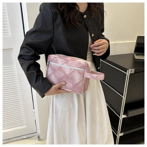 Détail de trousse de toilette matelassée rose avec fermeture éclair et poignée