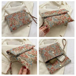 Floral print evening clutch bag showing magnetic closure and interior space for accessories