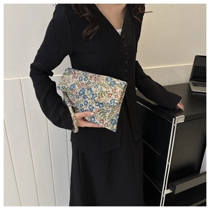 Close-up of vintage floral envelope clutch bag with red and blue embroidery details