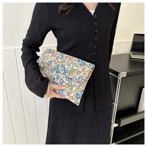 Close-up of vintage floral jacquard evening clutch with detailed colorful embroidery