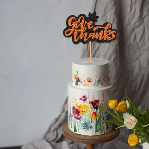 Glittery Give Thanks cake topper with orange maple leaves for Thanksgiving party decor