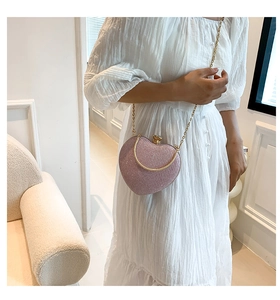 Pink glitter heart bag with gold crown lock and chain strap on white dress detail