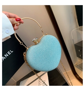 Detail of light blue glitter heart clutch with gold round handles and chain strap
