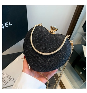Detail of heart-shaped glitter evening bag with gold metal frame and crystal clasp