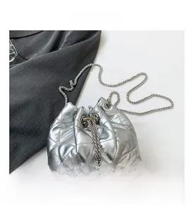 Detail of silver quilted bucket bag with metallic finish and metal chain strap