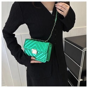 Sac à bandoulière matelassé vert métallisé avec fermoir doré sur chemise noire