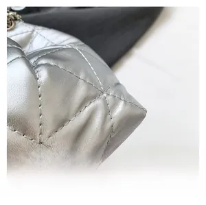Detailed macro view of silver quilted leather bucket bag showing refined stitching textures