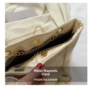 Gros plan du fermoir magnétique doré et de la texture matelassée du sac beige