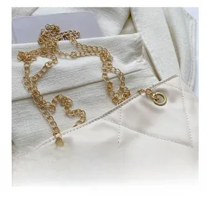 Détail de la bandoulière en chaîne dorée et du cuir matelassé beige sur le sac bandoulière