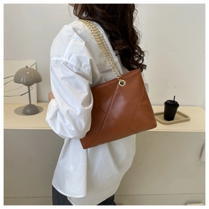 Vue détaillée du sac cabas en cuir matelassé marron avec bandoulière chaîne dorée