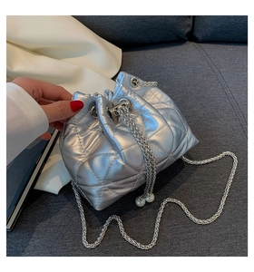Detailed view of silver quilted bucket bag featuring drawstring pearls and chain strap