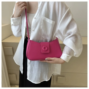 Detailed close-up of fuchsia shoulder bag featuring a modern relief clasp and matte finish