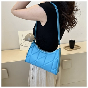 Detail showing classic diamond-quilted pattern and texture of the bright blue shoulder bag
