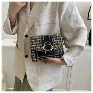Detail of tweed and leather patchwork bag with gold chain strap and metal clasp