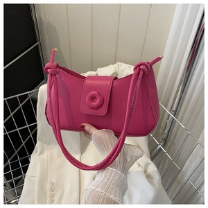Detail of rose pink underarm bag featuring a unique ring buckle and knotted strap design