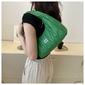 Close-up of a green quilted shoulder bag with diamond stitching and silver zipper detail