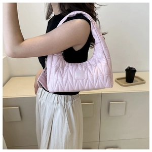 Detail of pink quilted shoulder bag showing soft leather texture and stitch patterns