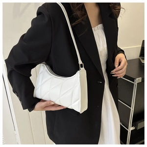 Close-up of a white quilted shoulder bag with gold hardware and fine stitching detail