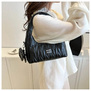 Detail of black pleated shoulder bag with mini pouch showing textured vertical quilting