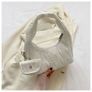 Close-up of white quilted hobo bag with matching mini pouch and AKOBIA PEOPLE tag