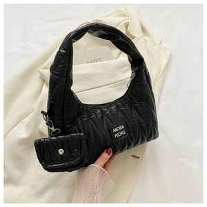 Close-up of quilted black handbag with AKOBIA PEOPLE label and mini pouch attachment