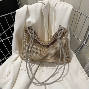 Luxurious gold rhinestone mesh hobo bag with knotted silver chain strap on white blazer
