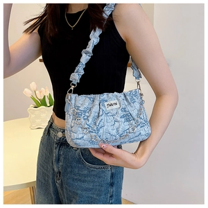 Detail of light blue pleated shoulder bag with floral silver chain and brand label