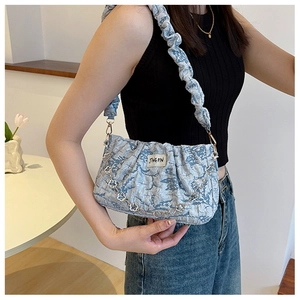 Détail du sac à bandoulière plissé bleu clair avec chaîne métallique florale argentée