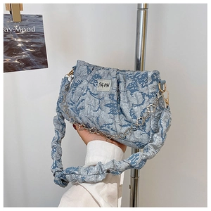 Détail d'un sac à bandoulière plissé bleu clair avec chaîne argentée et logo JING PIN